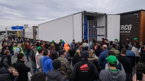 Des agriculteurs manifestants vérifient le contenu des camions à la sortie de l'autoroute A9 reliant l'Espagne et la France, au Boulou, au sud de Perpignan, le 1er février 2024.