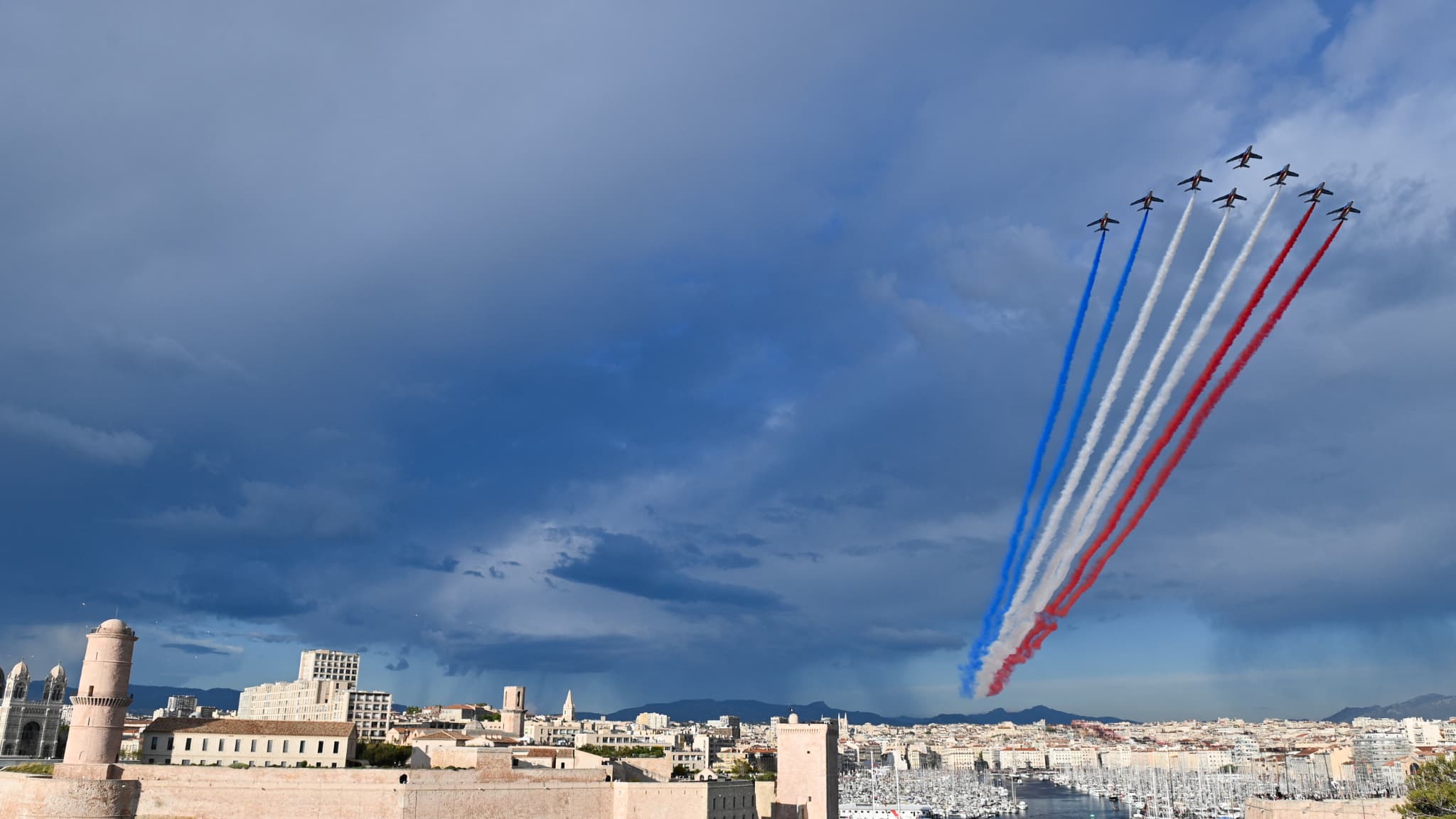 La Patrouille de France passe au-dessus de Marseille à l'arrivée de la flamme olympique dans le Vieux-Port, le 8 mai 2024.