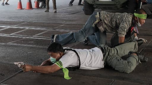 Un manifestant anti-gouvernement smaedi à Bangkok.