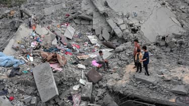 Des gens constatent la destruction d'une maison de la famille palestinienne al-Atrash, après avoir été détruite lors d'une frappe israélienne à Deir el-Balah, dans le centre de la bande de Gaza, le 13 mars 2024.