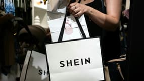 Une cliente porte des sacs après avoir fait des achats dans une boutique éphémère de la marque asiatique Shein, le 26 juin 2025 à Dijon, en Côte-d'Or (photo d'illustration).