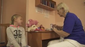 Une bénévole de l'ONG Frida Ukraine en rendez-vous avec une petite fille dans un village du sud du pays.