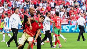 Un membre du service de sécurité avec un jeune supporter du Maroc à Saint-Etienne 