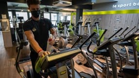 Un employé d'une salle de fitness du centre-ville de Strasbourg nettoie une machine, le 7 juin 2021, deux jours avant la réouverture des salles de sports fermées depuis 7 mois en France en raison de l'épidémie de Covid-19.
