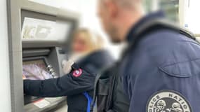 Un policier s'adresse à une personne qui retire de l'argent à un distributeur de billets (Illustration)