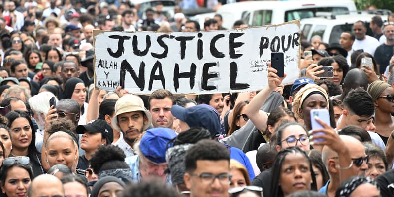 Des personnes tiennent une pancarte "justice pour Nahel" lors de la marche blanche organisée à Nanterre, ce jeudi 29 juin 2023.