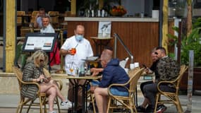 Des touristes prennent un verre à la terrasse d'un restaurant de Palma de Majorque, très prisée des Allemands, le 26 mars 2021