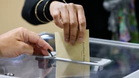 Une électrice glisse son bulletin dans une urne du Touquet pour le premier tour des législatives, le 12 juin 2022.