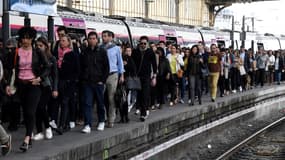 Des voyageurs sur le quai d'une gare.