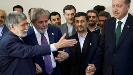 Le président brésilien Lula da Silva (2e à gauche) et son ministre des Affaires étrangères Celso Amorim (à gauche), main dans la main avec le président iranien Mahmoud Ahmadinejad et le Premier ministre turc Recep Tayyip Erdogan à Téhéran. L'Iran a signé