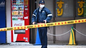 Un officier, derrière un cordon de police après un incendie, à Osaka, au Japon, le 17 décembre 2021