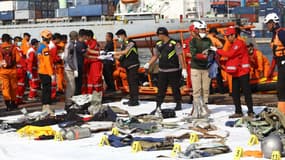 Des sauveteurs indonésiens ramènent des débris de l'avion à terre