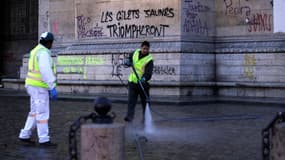 Des agents d'entretien nettoient les graffitis sur l'Arc de Triomphe, le dimanche 2 décembre. 