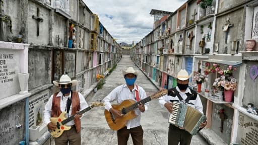 Les chanteurs Roberto Maldonado (g) Humberto Montès (c) et Israel Mundo (d) au cimetière de Ciudad Nezahualcóyotl, attendent, le 3 juin 2020 des familles qui leur demanderaient de chanter lors de l'enterrement de leurs proches