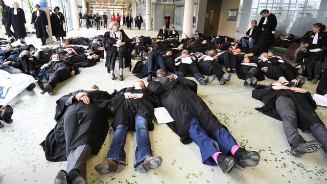 Des avocats et magistrats se couchent au sol en signe de protestation, le 30 mars 2018, au TGI de Nanterre. 
