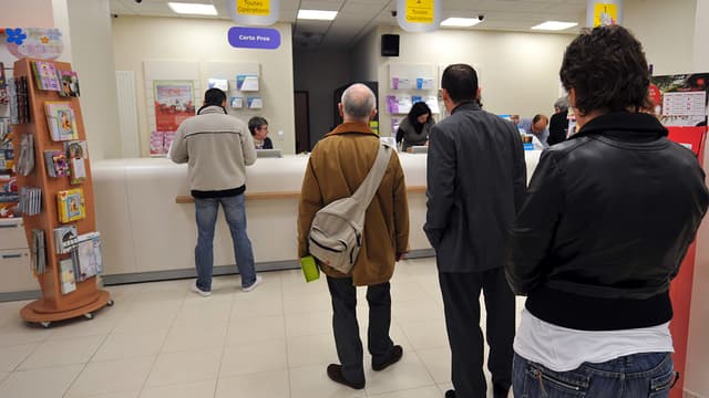 Des clients font la queue devant un guichet de la Banque postale (photo d'illustration).