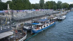 Des bateaux sur la Seine près des tribunes qui accueilleront le public pour la cérémonie d'ouverture des JO, le 25 juillet 2024