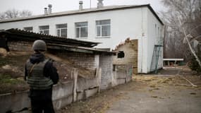 Un soldat ukrainien se tient près d'un mur endommagé par un bombardement à Stanytsia Louhanska, opéré par des séparatistes pro-Russes.