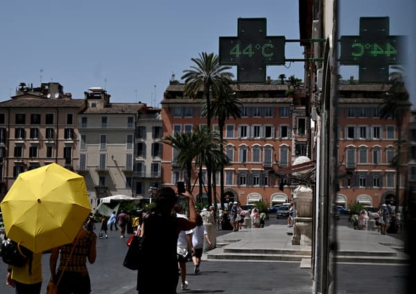 Des piétons marchent sous l'enseigne d'une pharmacie indiquant la température extérieure actuelle près de la fontaine Barcaccia devant la Place d'Espagne à Rome le 17 juillet 2023, lors d'une vague de chaleur en Italie. Des piétons marchent sous l'enseigne d'une pharmacie indiquant la température extérieure actuelle près de la fontaine Barcaccia devant la Place d'Espagne à Rome le 17 juillet 2023, lors d'une vague de chaleur en Italie.