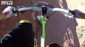 Un cycliste roule à flanc de falaise en VTT