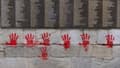 Des mains rouges taguées sur le Mur des Justes au Mémorial de la Shoah à Paris, le 14 mai 2024.