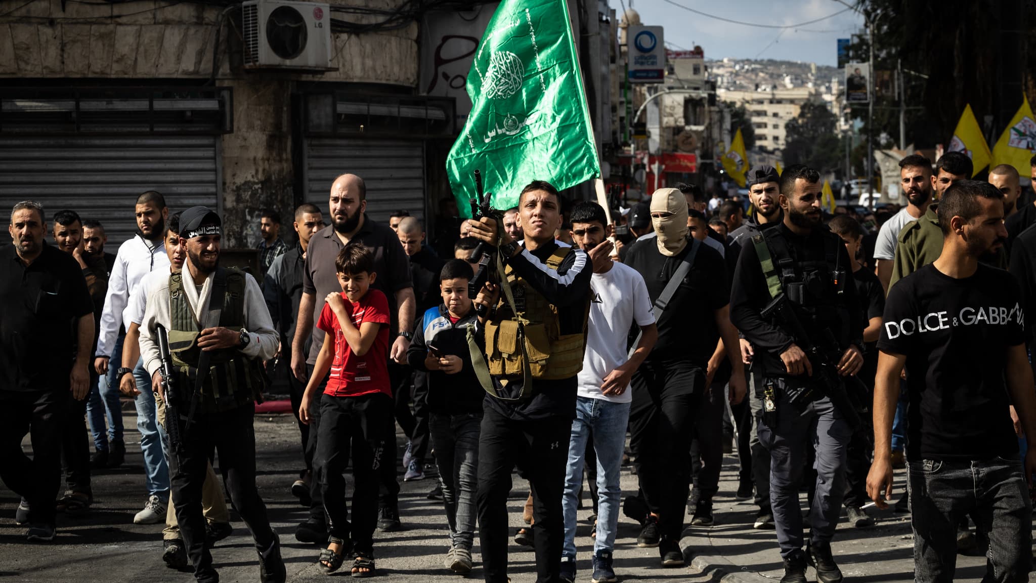 Des Palestiniens, dont certains en armes, assistent aux funérailles d'hommes tués lors d'un raid nocturne de l'armée israélienne dans le camp de réfugiés de Jénine, en Cisjordanie occupée, le 17 novembre 2023. 