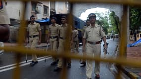 Des policiers indiens patrouillent le long d'une rue menant la résidence de Yakub Memon.