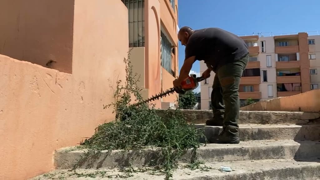 Un paysagiste en train de déblayer des escaliers de la cité Bassens à Marseille.
