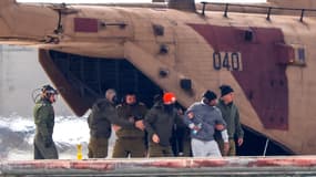 L'otage nouvellement libéré Avera Mengistu (au centre), flanqué des forces de sécurité, débarque d'un hélicoptère militaire sur l'héliport du centre médical Sourasky (Ichilov) à Tel Aviv le 22 février 2025.