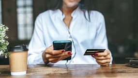 Une femme effectuant un paiement avec sa carte bancaire depuis son téléphone.