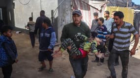 Un homme porte une enfant blessée dans un bombardement dans le camp de Nuseirat à Gaza le 19 mars 2025