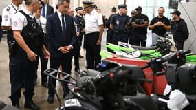 Le ministre de l'Intérieur français (4e à g) devant des deux-roues saisis par la police après des rodéos urbains à l'hôtel de police de Créteil, le 17 août 2022