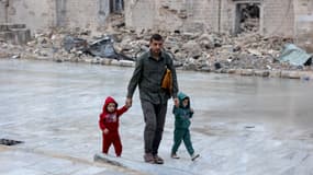 Un Palestinien marche avec ses enfants le 10 avril 2024 dans la cour de la mosquée historique Omari de la ville de Gaza, qui a été lourdement endommagée par les bombardements israéliens lors des combats en cours entre Israël et le Hamas, après la prière du matin du premier jour de l'Aïd al-Fitr qui marque la fin du Ramadan.
