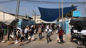 Des habitants récupèrent des sacs d'aide alimentaire de l'ONU à Deir al-Balah dans la bande de Gaza, le 28 octobre 2023