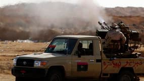 Insurgés libyens sur la ligne de front, près d'Ajdabiah, jeudi. Les forces loyales à Mouammar Kadhafi ont tué un rebelle vendredi à un kilomètre de l'entrée ouest d'Adjabiah, dans l'est de la Libye, indiquent des insurgés, qui peinent à lancer une contre-
