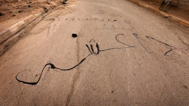Inscriptions signifiant "A bas Daesh" sur une route irakienne.