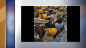 Les secouristes sur le point de sortir le survivant des décombres