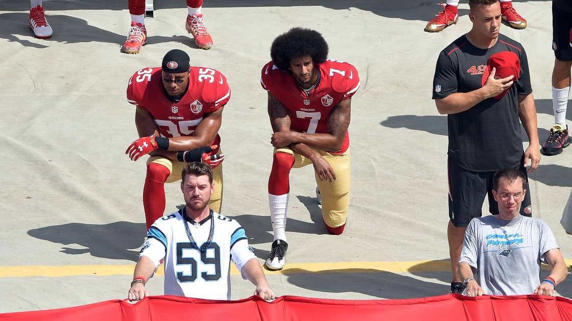 Colin Kaepernick (à droite), avec un genou à terre lors d'un match de la NFL.