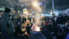 Les manifestants ukrainiens se réchauffent à côté d’un feu sur la place de l’Indépendance à Kiev, le 14 décembre.