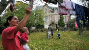 Une femme d'une famille Kosovare, réfugiée et demandeuse d'asile étend le linge, en 2009 en banlieue d'Angers, dans le jardin du pavillon qu'ils squattent faute de pouvoir bénéficier de places d'hébergement