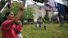 Une femme d'une famille Kosovare, réfugiée et demandeuse d'asile étend le linge, en 2009 en banlieue d'Angers, dans le jardin du pavillon qu'ils squattent faute de pouvoir bénéficier de places d'hébergement