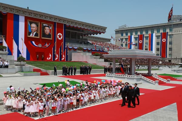 Le dirigeant nord-coréen Kim Jong Un et le président russe Vladimir Poutine passent devant des enfants lors d'une cérémonie de bienvenue sur la place Kim Il Sung à Pyongyang, le 19 juin 2024. 