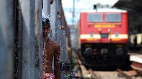 Un jeune indien sous un tuyau d'évacuation d'eau en 2010. Chaque année, la canicule en Inde tue des centaines de personnes.