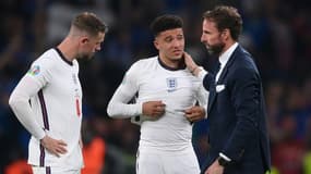 Le sélectionneur de l'équipe d'Angleterre, Gareth Southgate, réconforte l'attaquant Jadon Sancho, après la défaite en finale de l'Euro face à l'Italie (1-1, 3-2 t.a.b..), le 11 juillet 2021 au stade de Wembley à Londres