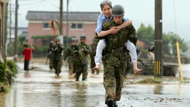 Des militaires japonais aident la population à évacuer, le 6 juillet 2017 à Asakura