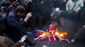 Des manifestants brûlent un drapeau britannique, mardi, devant l'ambassade de Grande-Bretagne à Téhéran. L'Iran encourt de "graves conséquences" après l'intrusion de manifestants dans l'ambassade de Grande-Bretagne, a averti mardi le chef de la diplomatie