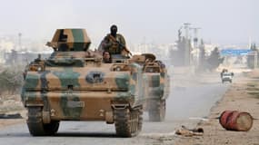 Des combattants rebelles appuyés par l'armée turque dans un véhicule blindé se dirigent vers la ville d'Al-Bab, le 9 février 2017 en Syrie