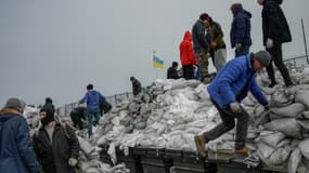 Des habitants remplissent des sacs de sable pour les lignes de front, sur la plage d'Odessa (Ukraine), au bord de la mer Noire, le 7 mars 2022