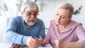 Un couple de retraités remplissant un document (photo d'illustration)