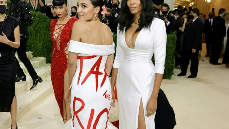 Alexandria Ocasio-Cortez (g) en robe de soirée blanche marquée du message en lettres rouges "Tax the Rich" ("Taxez les riches) au gala du Metropolitan Museum of Art (Met), le 13 septembre 2021 à New York Alexandria Ocasio-Cortez (g) en robe de soirée blanche marquée du message en lettres rouges "Tax the Rich" ("Taxez les riches) au gala du Metropolitan Museum of Art (Met), le 13 septembre 2021 à New York
